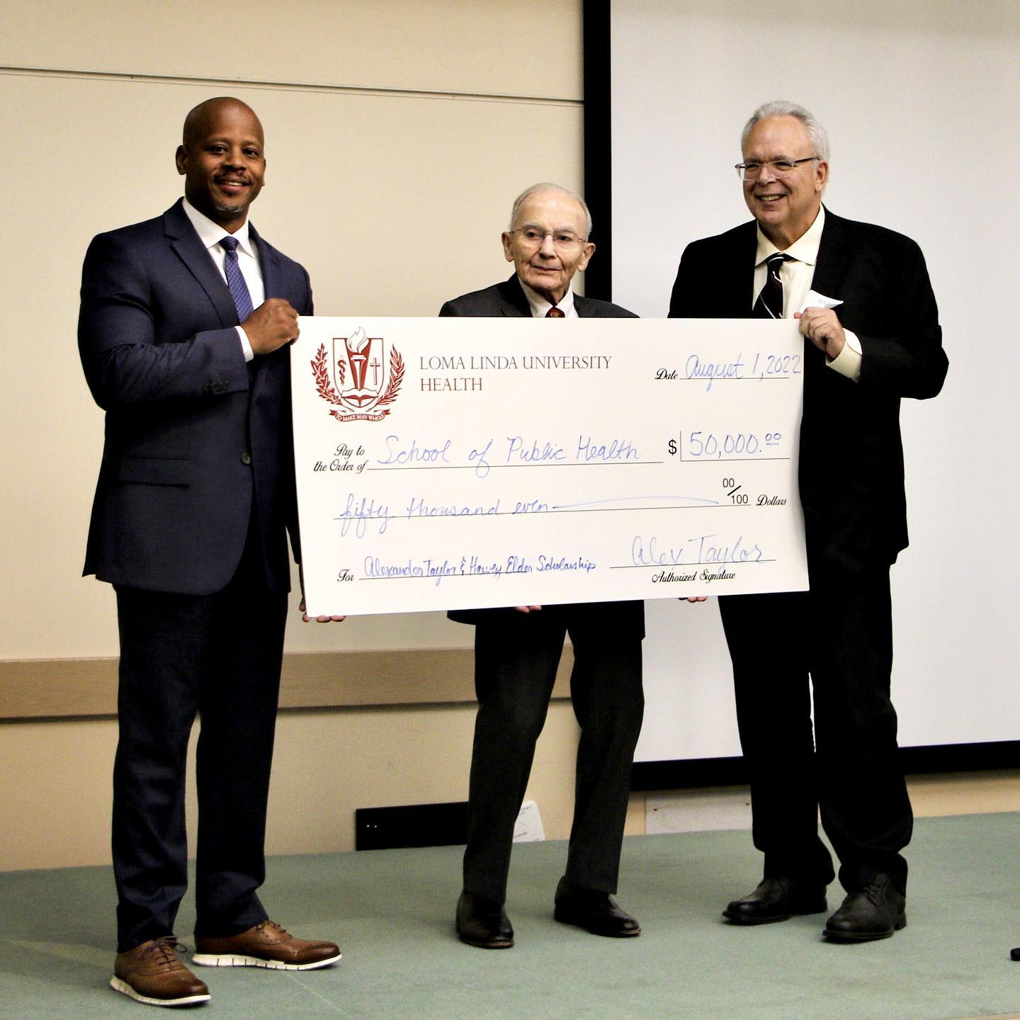 Harvey Elder and Alexander Taylor holding Epidemiology Scholarship check