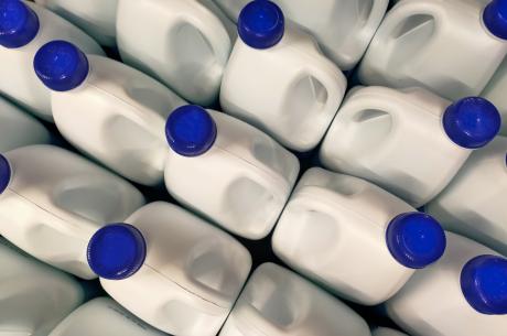 white plastic containers of bleach with blue lids