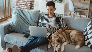 student on zoom with dog by his side