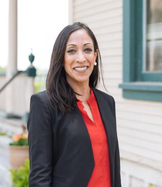 Woman in a black suite wearing a red shirt