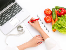 laptop, salad, and a women's hand taking notes