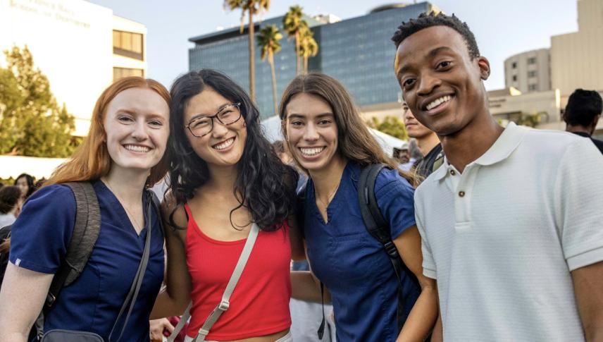 students smiling with buildings in background