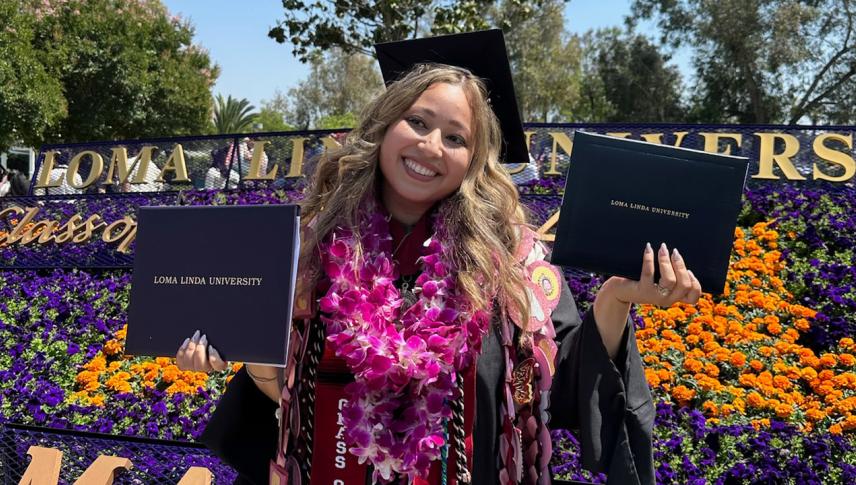 graduate student wearing leis and holding diplomas